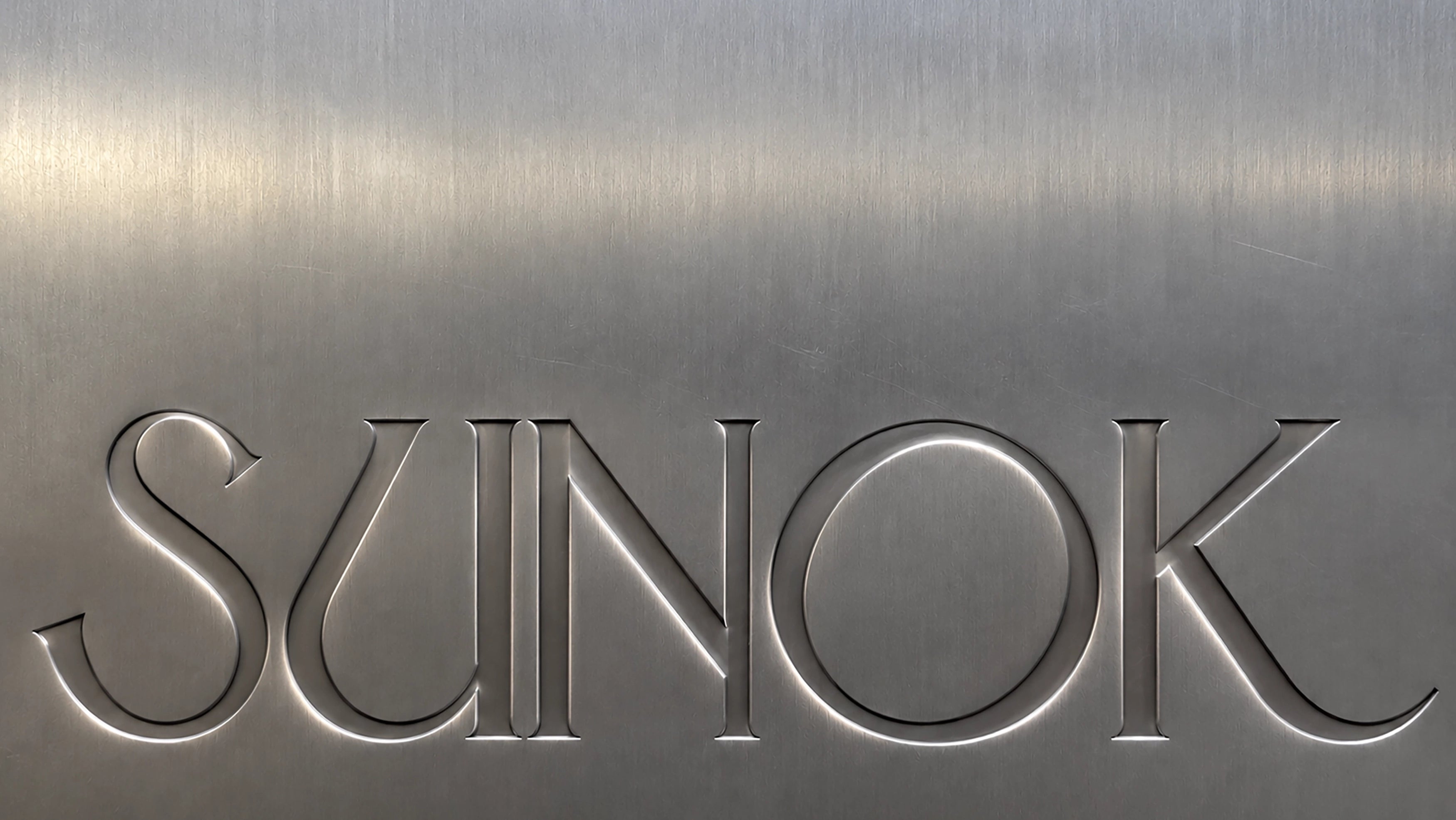 SUNOK wordmark embossed in brushed metal — design-led makeup brushes and tools